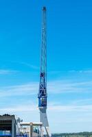 Towering crane amidst a clear blue sky at a busy construction site enhancing city infrastructure and progress photo