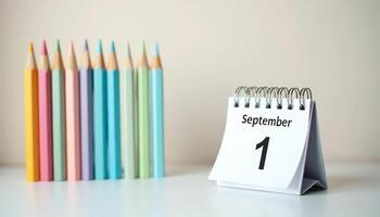September 1 calendar and pastel pencils on desk. First day of school, new academic year, learning start. photo