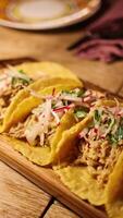 A variety of tacos with vibrant toppings on a wooden platter in warm, ambient lighting video