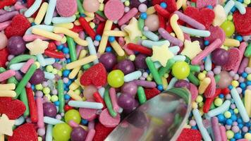 Macro view of a spoon scooping vibrant, multicolored sprinkles, showcasing texture and color in a playful, dynamic sequence video