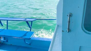 A boat glides through vibrant turquoise waters near Phuket, Thailand, with a focus on the metal handle and ocean waves video