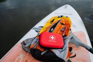A bright red first aid kit secured on a sturdy paddle board is essential when kayaking to ensure youre prepared for any emergencies that may arise during your adventure photo