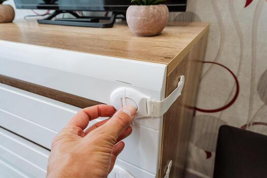 An expert is installing a highsecurity lock on a dresser to safeguard its valuable contents from unauthorized access, preventing potential loss or damage from theft or mishandling photo