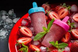 Strawberry popsicles with mint leaves photo