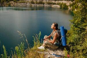 A Serene Hiker Enjoying a Beautiful Day by a Tranquil Lake Surrounded by Natures Beauty photo