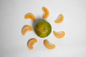 Citrus creativity orange segments form a circle around a whole fruit, resembling a sunburst. photo