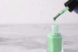 A drop nail gel drips from the brush. Professional manicure products photo