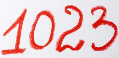 A number written in red chalk or pastel on a white background, with the texture of the strokes visible photo