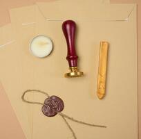 A wax seal kit including wax sticks, candles, stamp and sealed scroll placed on a neutral background photo