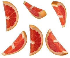 Several sliced red grapefruit wedges from different angles, placed on an isolated background photo