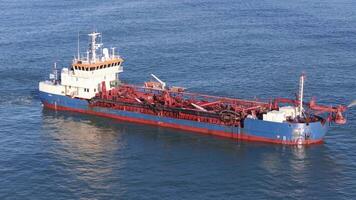 A dredging vessel pumps sand in calm ocean waters near Gold Coast, Australia, under clear skies with steady camera angles video