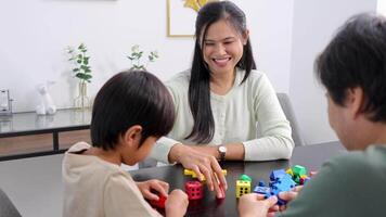 A family joyfully engages in building with colorful blocks at a table, fostering creativity and connection video
