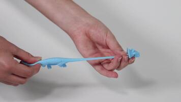 Hands stretching a blue dinosaur toy video
