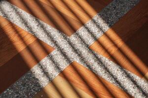 In the afternoon light, slanted shadows fall across brown tiles marked with white lines. photo