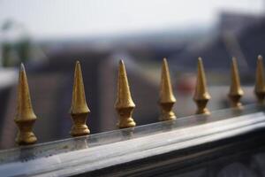 The guardrail decoration is in the form of a gold triangle with sharp edges and a blurred background photo