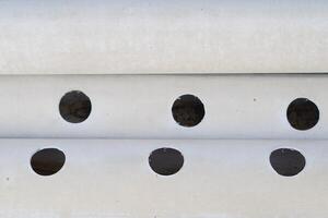 White pipe with round holes along the pipe photo