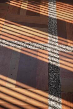 oblicuo líneas de sombra tramo terminado el superficie de marrón losas con blanco patrones durante el tarde foto