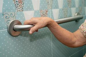 elderly woman patient use handrail safety in toilet support rail bathroom. photo