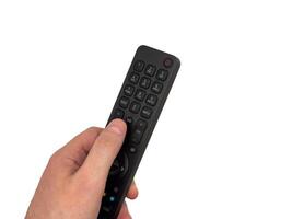 White male hand on white background presses buttons on TV remote control, man switches channels with remote control, for banners, for TV advertising. Copy space, flay lay, top view. photo