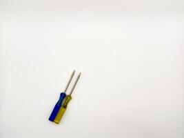Two small colored plastic screwdrivers on a white background, blue and yellow. copy space, flay lay, top view photo
