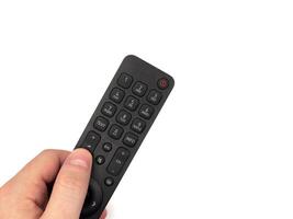 White male hand on white background presses buttons on TV remote control, man switches TV channels with remote control, for banners, for TV advertising. Copy space, flay lay, top view. photo