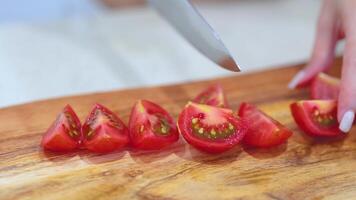 Close-up of hands slicing ripe tomatoes on a wooden board. Bright lighting enhances the fresh, vibrant colors video