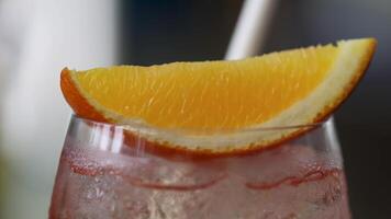 Close-up of a chilled Aperol Spritz with an orange slice garnish, highlighting condensation and vibrant colors video