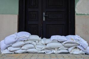 Sandbags stacked in front of door for flood protection photo