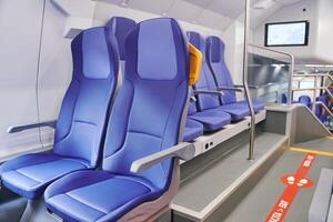 Modern high speed train interior with empty blue seats photo