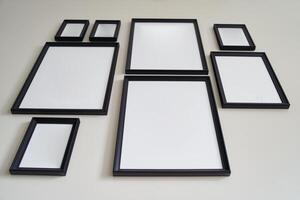 Different size framed photos hanging on the gray wall. Mockup.