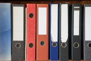Colored folders for office files and paper on a shelf. Background image photo