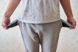 Inverted empty pockets. The young man turned out empty jeans pockets. photo