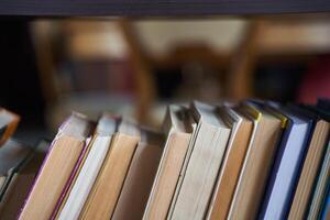 piles of books on a wooden bookshelf. photo