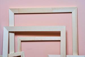 Wooden frames on a pink background. Frames for photos and paintings