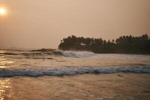 Sunset on the ocean with big waves in Sri Lanka photo