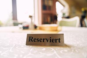 Iron plate with the inscription reserved on a table in a restaurant. photo