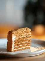 Slice of layered honey cake selective focus. Perfect piece of layered honey cake in restaurant bokeh background. Traditional Russian layer cake Medovik made with honey photo
