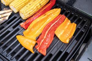 Grilled corn and bell peppers on bbq grill for a summer feast photo