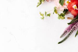 Bouquet of red peony and other flowers on white table photo