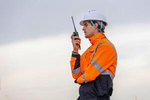 Maritime Safety Engineer Working at Port Terminal with Walkie Talkie, Dock Worker in Safety Uniforms Using Technology for Port Operations, Industrial Engineer Collaborating at Harbor Site photo