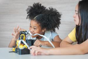Young Girls Engaged in Robotics and STEM Learning, Diverse Kids Building a Robot Arm in a Science Workshop, Two Girls Exploring Technology and Innovation photo