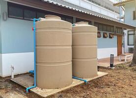 the water tank and water pump installed outside the building. For use as a reserve of water for use in homes and offices. Made of special grade material, extra thick, UV protection and not moss. photo