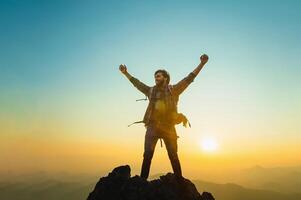 man is standing on a mountain top, looking out at the horizon photo