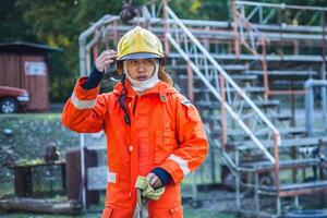 man in an orange fireman's uniform is standing in front of a building photo