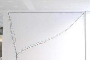 Interior renovation building phase showcasing gypsum board ceiling with smooth edges. Electrical wire installation continues before plastering of ceilings. Successful project relies careful photo