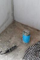 Feeling of progress in messy house renovation. Unfinished concrete floor and wall in corner showing construction detail and capped plumbing pipe awaiting work photo