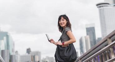 Happy young southeast asian woman teenager blogger using smartphone for searching travel guide. World explorer with local cultural experience on Chao Phraya river in Bangkok Asia tourism concept photo