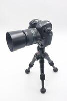 Camera on tripod positioned for capturing clear images in a studio setting with neutral background during indoor photography session photo