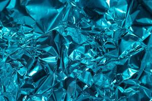 Shiny blue foil texture with crumpled surface captured under natural light photo