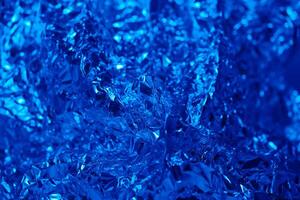Shimmering blue foil creating an abstract artistic texture with intricate details and reflections in captivating light photo